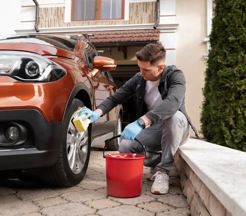 Lavage auto à domicile Saint-Georges-des-Coteaux : professionnel intervenant sur un véhicule